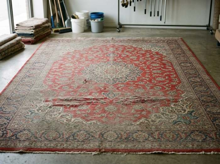 Tapis de soie à fond rouge photographié à l'arrivée, avant lavage